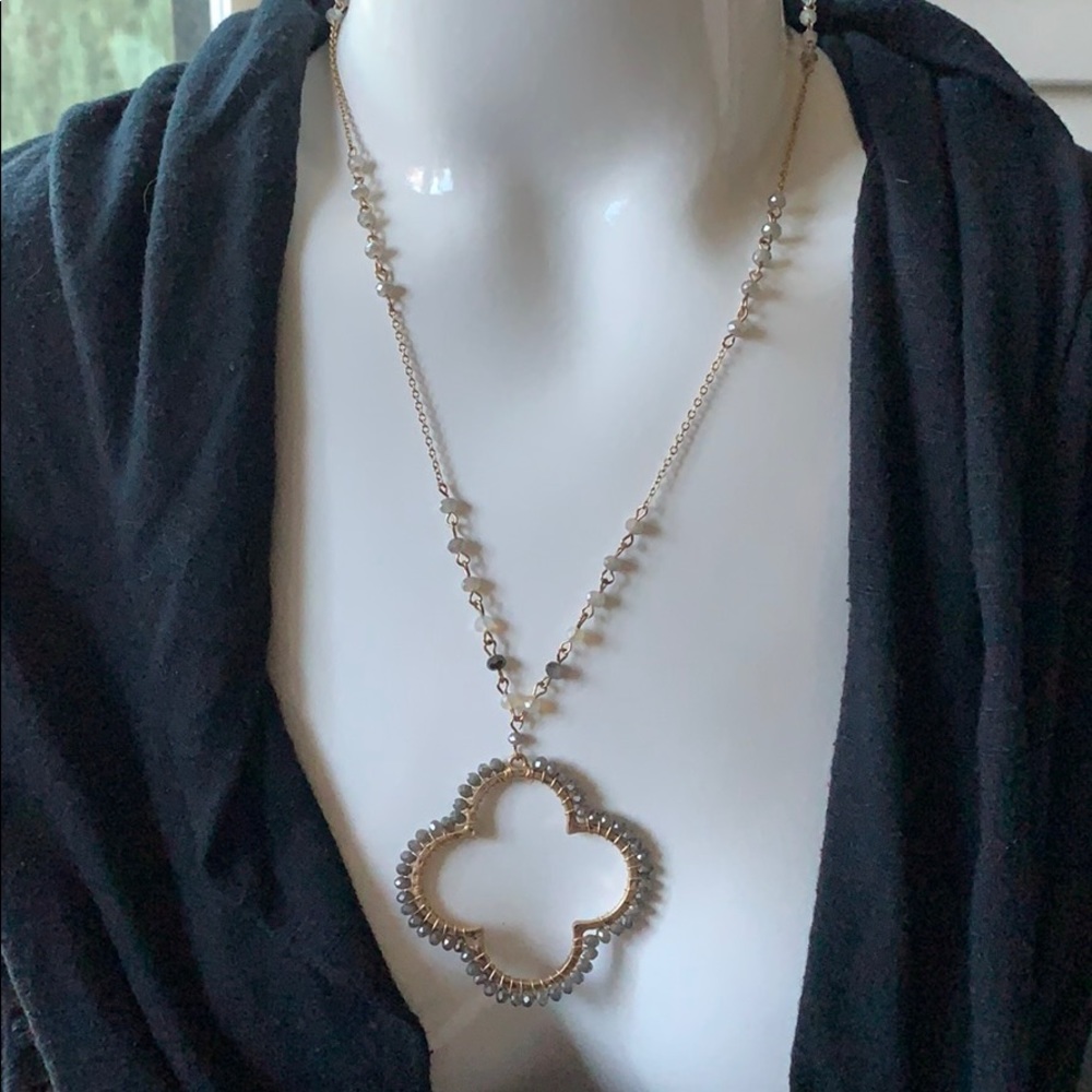 Long gold necklace with beaded pendant.